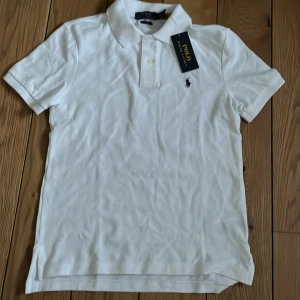 Vit Ralph Lauren piké - Vit Ralph Lauren piké perfekt för sommaren. Tröjan är helt oanvänd och lappen är kvar. Nypris 800kr+. Kommer att strykas vid köp.