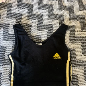 Linne addidas  - En svart croptop från adidas med gula detaljer storlek s men väldigt stretchig 