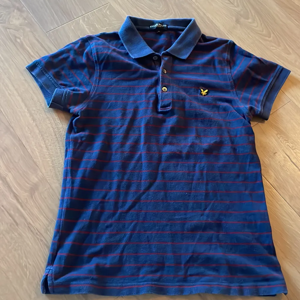 Säljer denna riktigt snygga vintage pikén från Lyle Scott som är blå och röd randig Den är storlek M men ganska liten Hör av dig vid frågor😊. T-paidat.