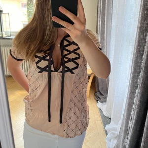 Rosa blus - Kortärmad blus med satinband. Använd, har lite lösa trådar som kan klippas bort, annars fin 🫶