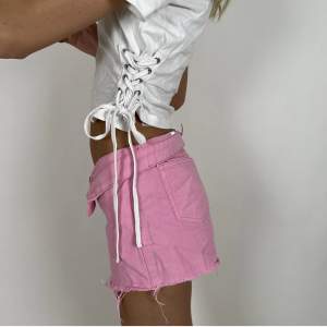 Rosa shorts i storlek 36. Modellen är 177 cm.