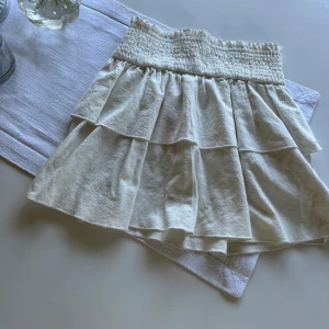 Vit/krämvit volangkjol - Vit volangkjol ned resor i linningen.Bara använd ett fåtal gånger