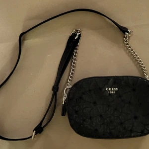 Väska från GUESS - Ny priset låg runt 1000kr och den är inte använd många gånger, den är jätte snygg men då jag inte använt den så mycket är det på tiden att den hittar ett nytt hem. Den är mellan 15-20cm