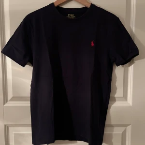 Polo Ralph Lauren t-shirt, strl S - Polo Ralph Lauren tee Marinblå Strl. S Mycket fint använt skick.  Kommer från ett rök och djurfritt hem. 