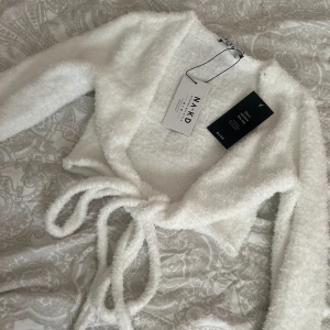 Kofta i vit  - Kofta med knytning, storlek s. I nyskick med prislapp kvar. Endast testad. 