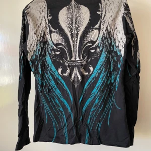 Långärmad t-shirt rockig - Svart tröja med tryck baktill. Bredd46cn  Köpare betalar frakt