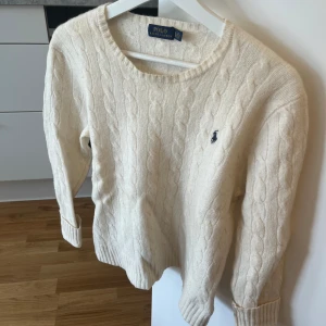 Ralph Lauren stickad tröja - Vit stickad Ralph lauren, var storlek M från början men råkat krympa i tvätten till S! Väldigt gott skick🌸
