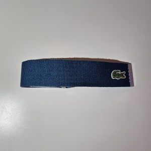Blått lacoste bälte  - Blåa lacoste bälte, använt fåtal gånger.