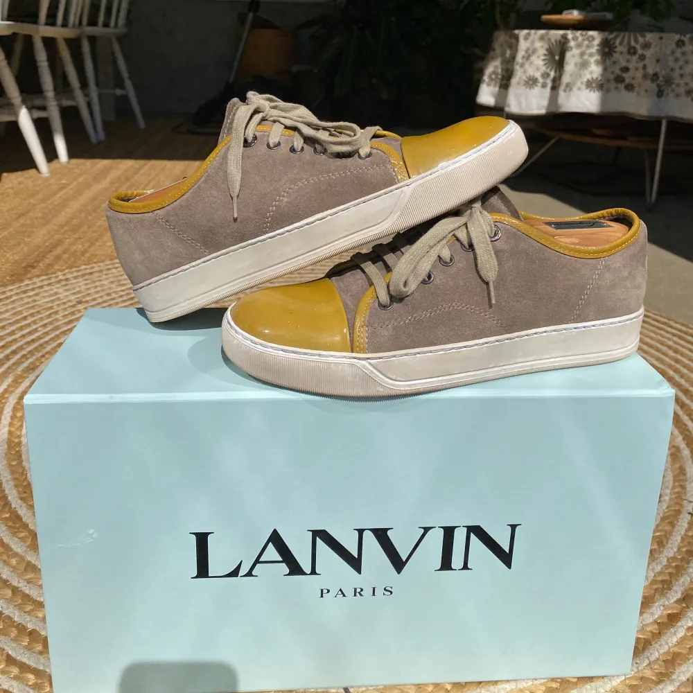 Hej, säljer ett par Lanvin cap Toe sneakers med glansig tå. Beige mocka med gula detaljer. Nypris 4600kr. Box medkommer. Size UK 5 vilket motsvarar 39/40 EU. Finns några mindre skavanker som finns på bild i DM. Pris kan diskuteras. Hör av dig!. Skor.