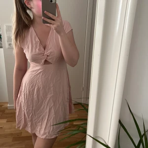 Klänning - Rosa linneklänning från Vero Moda med rosett och öppen rygg! Väldigt skrynklig men kommer strykas innan den skickas iväg. Helt oanvänd! Ord. pris 350kr men köptes för 175kr