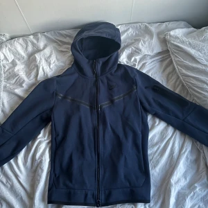 Blå Nike Tech - En blå Nike tech som är i fin skick. Den har använts ett tag men det finns inga skador på den. Pris kan diskuteras vid snabb affär. Inga oseriösa!