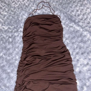 Klänning - Klänning från Shein i strl XS, brun, med scrunch nere. Öppen rygg. Kontakta för mer information/fler bilder. Kan postas men köpare står för frakten, kan mötas upp i malmö. 