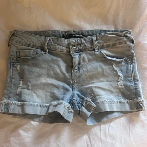 Ljusblåa jeansshorts - Fina jeansshorts, midja rakt över 40cm, stretch, skulle uppskatta storlek M/L 38/40, bilderna i annonsen är dem som finns