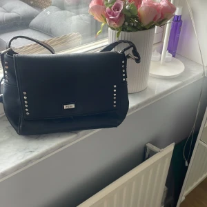 Axelremsväska - Jag säljer nu denna väska från feel, den har synliga tecken av användning därmed priset. Annars en väldigt fin väska som rymmer mycket nu till skolan när man ska ha med sig mycket💕 Köpt för 150kr här på plick💕