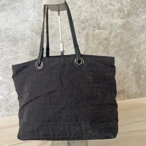 Fendi Zucca liten väska - Äkta Fendi väska. Köpt på en dansk vintage butik.Väskan har några spår av användning som syns på bilden. Väskan har tre fack. Fler bilder skickas vid intresse.  Bredd: 25cm  Höjd: 22cm  Djup: 10cm  Axelfall: 15cm