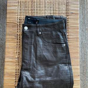 Mönstrade/krokodilmönstrade byxor i jeansmodell från Asos. Produktkategori: Asos Tall Extra långa byxor. Aldrig använda.