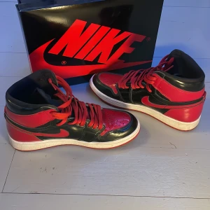 Jordan 1 Retro High OG patent bred röd-svarta - Säljer nu mina äkta jordans 1 mid patent bred då de är för små  Kvalite 7/10 säljer billigare då det finns en liten skada bak på ena skon se på bilden  Köpta för 3500kr säljs med de svarta snörena, box och kvitto(Pris kan diskuteras, öppen för byta)