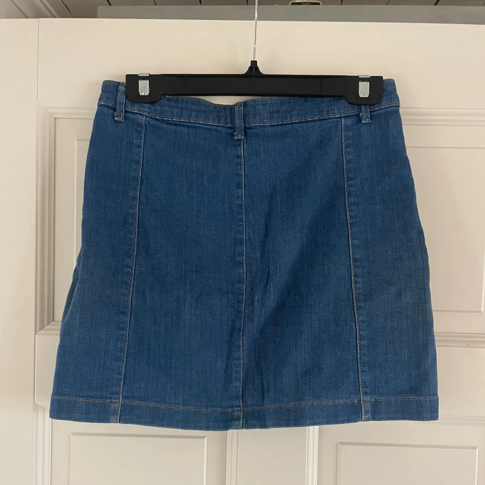 Söt jeans kjol från Gina Tricot med knappar fram till. Den är i en mer blåare färg jämfört med vanligt jeansmaterial.  Storlek 40. Kjolar.