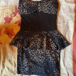 Leopardklänning - Off-shoulder leopardklänning som är svart runt midjan. Syns lite dåligt på bilden men klänningen slutar precis när den försvinner ur bilden. Står inget märke. Sitter som S-M✨nyskick