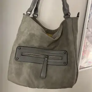 Så snygg grå handväska, inga defekter! Dator får plats i! Vet ej märke! Går att ha på axeln om man skulle vilja det!