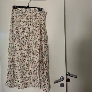 Långkjol  - Långkjol med dragkedja, blommor som detaljer.