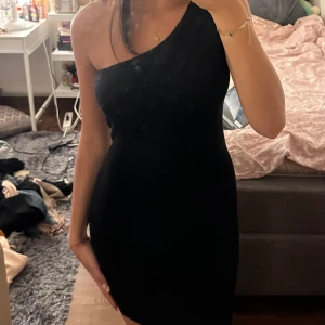 Svart one-shoulder klänning - En elegant svart one-shoulder klänning som är tight och kort. Perfekt för festliga tillfällen. Aldrig använt. 