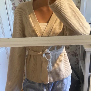 Krämvit stickad kofta - Jättefin men använd bara en gång. Skön till hösten! Bandet sitter inte fast! Inga defekter 