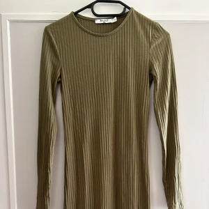 Klänning  - Militärgrön klänning, går typ till knäna. 