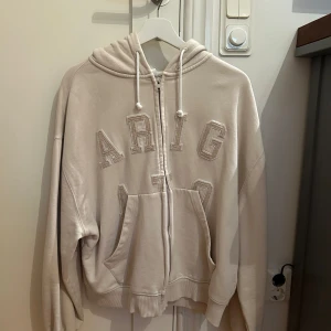 Axel Arigato Zip Hoddie Stl M - Axel arigato hoddie som säljs pga att den aldrig kommit till användning. Köpt på deras officiella hemsida för 2750kr. Hoddien är aldrig använd och i nyskick.