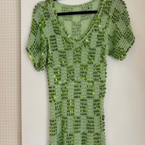 Paljett topp, 90-tal - Grön, virkad paljettopp från 90-talet. Uppskattar stl S(dam). Material okänt, men gissningsvis syntet.