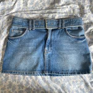 Supersnygg lågmidjad jeans kjol från secondhand! I fint skick men en bra sak att veta är att den lilla metallpinnen (bild 4) sitter lite löst så om man spänner kjolen för hårt så kan den trilla av men den kan sättas dit igen💕Den har ett egengjort hål