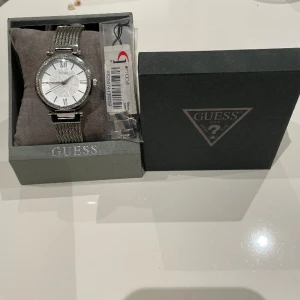 GUESS KLOCKA SILVER U0638L1 - En silver klocka från GUESS. Den har 10års garanti och köptes för 2 år sedan. Köpte den för 125$ i USA i butiken Macys. Den har skjusterbara förlängnings delar. Kommer med box och tagg, samt klockkudde. Ett bra pris för en sådan fin klocka.💨💥☀️🔝