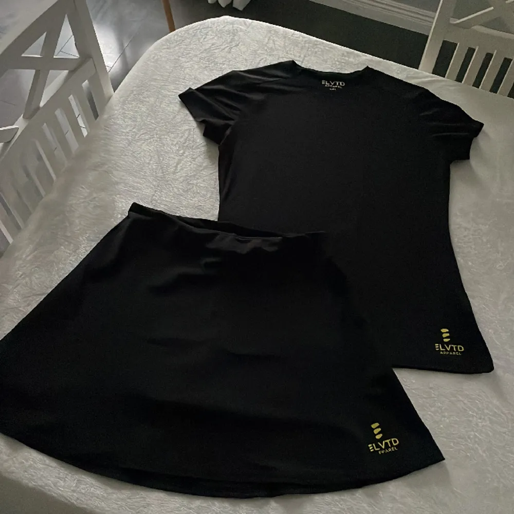 Svart padelkjol med insydd innerbyxa med tillhörande svart t-shirt.  Nytt, endast tvättat före jag skulle använt det. Säljes pga det är för litet för mig. . T-shirts.