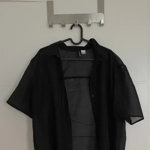 Tunn t-shirt med knappar - Tunn t-shirt med knappar från H&M som kan användas över en annan t-shirt eller linne. Den är använd ett fåtal gånger och är i bra skick. Säljer pga att den inte passar mig längre🩷köpare står för frakt.