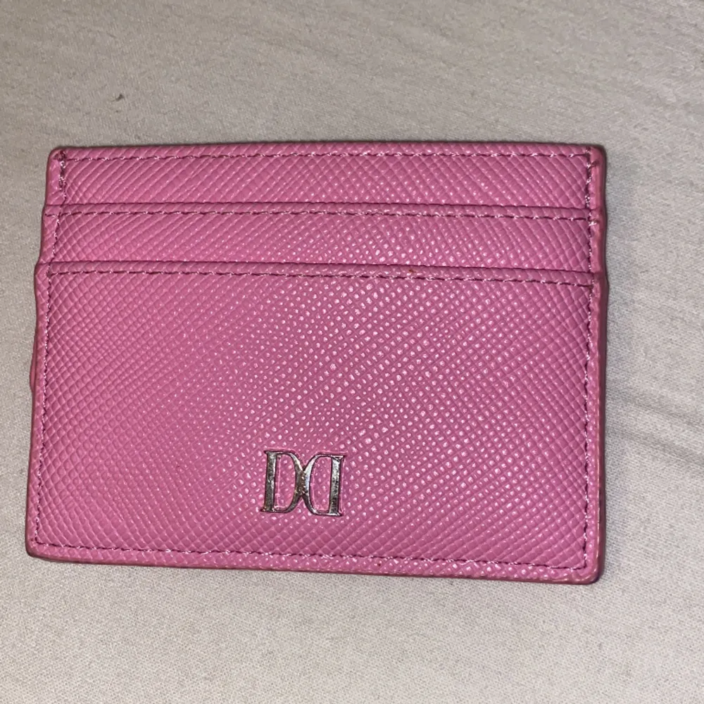 Det är en liten rosa plånbok från don donna. Den är helt ny.. Accessoarer.
