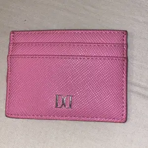 Det är en liten rosa plånbok från don donna. Den är helt ny.
