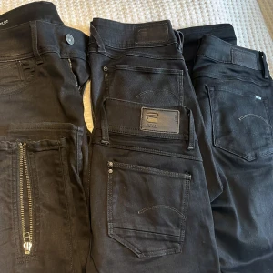 G-STAR RAW - 4 par svarta G-star. Ett par oanvända Lynn high super skinny 27/30, ett par 3301 high skinny 27/30 obetydligt använda. ett par Lynn mid skinny med dragkedja på benen 27/30 som nya. Pris 600 kr/par