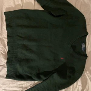 Grön stickad Raulph Luaren Tröja - As skön och stilig stickad polo tröja från Raulph Lauren. Den är storlek L men sitter som M. Inga hål eller defekter, tröjan är fräsch och felfri! Om ni har några frågor så är det bara att höra av sig! Nypris ca 1900kr! Modellen på bilden är 175cm. 