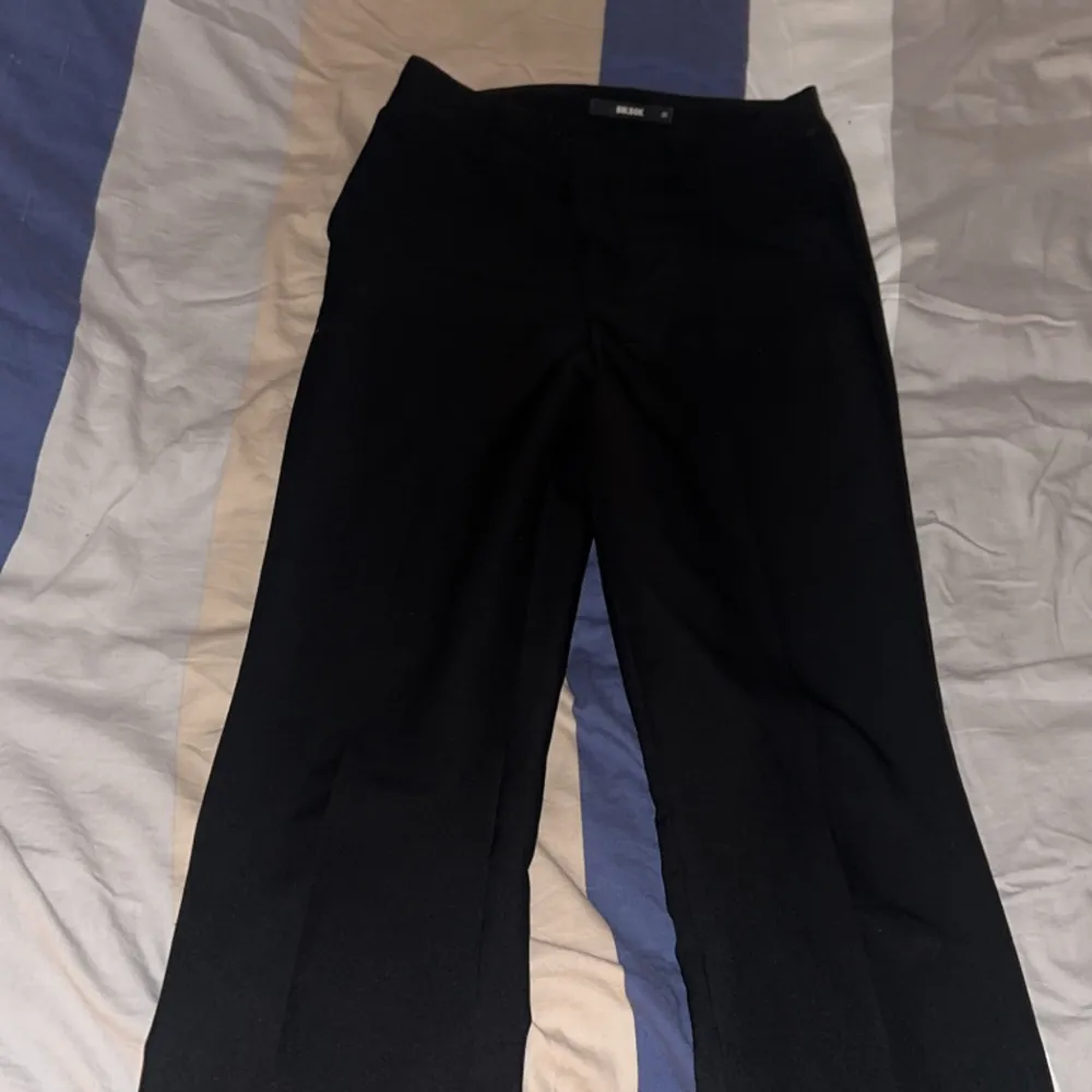Ett par svarta mid rise kostymbyxor från bikbok som är köpta för ett orginalpris på 599kr. Byxorna är nästan helt oanvända och är i nytt skick. Storleken är 36 (S).. Jeans & Byxor.