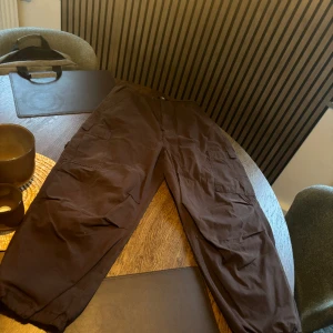 Jaded london parachute pants  - Jaded london parachute pants  Aldrig använda, har en cargo pants look Fint cargo pants material i burgundy färg Helt ny! 32/33