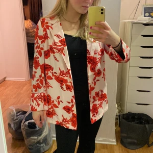 Blazer - En tunn blommig blazer från Gina tricot. Knappt aldrig använd. Den är rosa med röda blommor och lite kortare i ärmarna om man är lite längre. Köparen står för frakten.