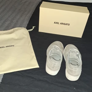 Axel Arigato Skor  - Ett par gråa Arigatos passar mellan [39-40] (Köpta för: 2500kr) (säljer för: 150 kr) pga får ingen användning av dom och har helt enkelt växt ur dom.  [Tillkommer en dustbag och själva skokartongen] 