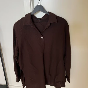 Brunt set - Brunt set med skjorta samt matchande byxor. Skjortan har vita knappar.   Säljer pga att den blivit för liten. Storleken är Xs men oversized så sitter mer som S.   Några trådar som sticker ut.    Ordinariepris: 329kr
