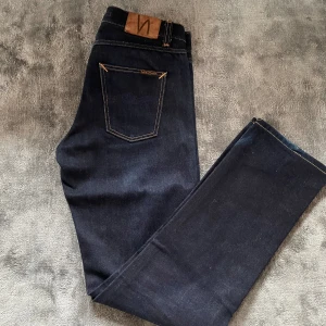 Mörkblå Nudie jeans - Feta Nudie jeans med mörkblå tvätt. Jeansen är knapp använda och är i gott skick. Org pris 1800. Modellen heter Gritty jackson. Hör av er vid frågor:)