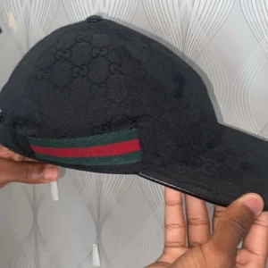 Gucci keps - En svart gucci keps där den är i storlek M. Ny använd ett få tal gånger. Lådan finns också kvar. 