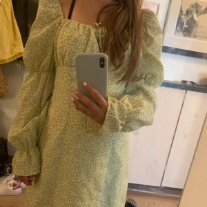 Gul blommig klänning från Divided - Jag säljer en supersöt gul klänning med blommor 🌸 Den är köpt från H&M förra sommaren & endast använd en gång så fint skick, skriv för fler bilder eller frågor🫶