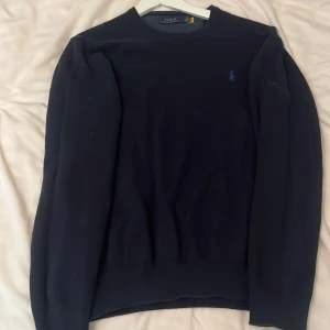 Stickad Ralph Lauren tröja - Fin mörkblå Ralph lauren tröja i mycket bra skick som tyvär inte kommer till användning som är i storlek M. Hör av er för mer info…