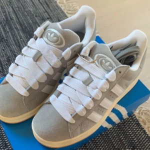 Gråa Adidas sneakers - hej! jag säljer mina gråa adidas campus då dom tyvärr är lite stora för mig. dom köptes i April men har används 3-4 gånger och ser ut som nya