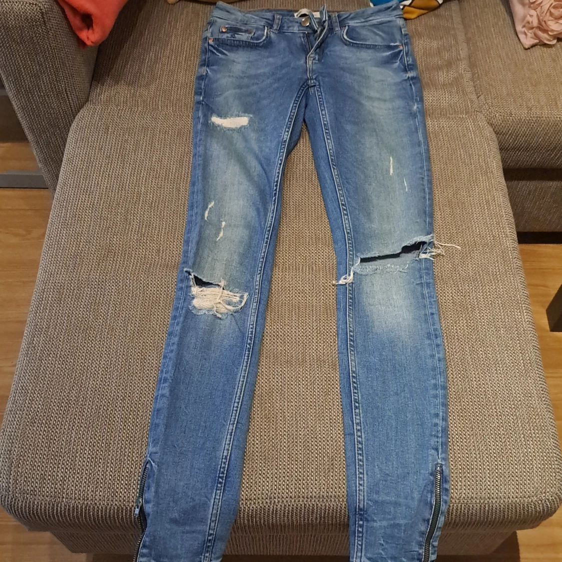 Blå slitna jeans med dragkedjor