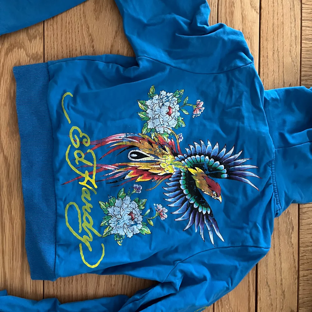 Säljer en jättesnygg ziphoodie från EdHardy x Urban Outfitters. Använd ett fåtal gånger men det finns en defekt på baksidan som syns på sista bilden. Storlek M men passar både S och XS. Skriv för fler bilder!❤️‍🔥 (pris kan diskuteras). Hoodies.